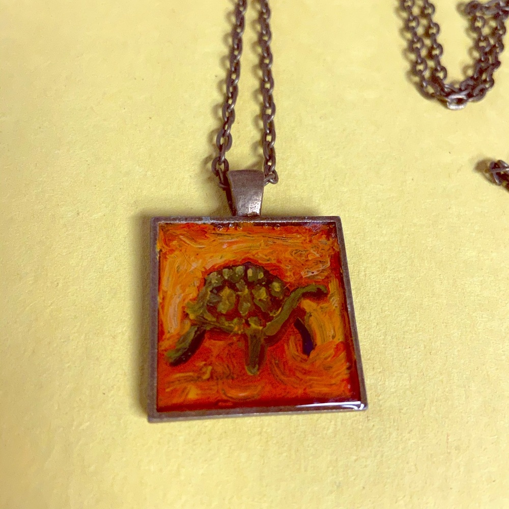 Glass and metal turtle necklace.